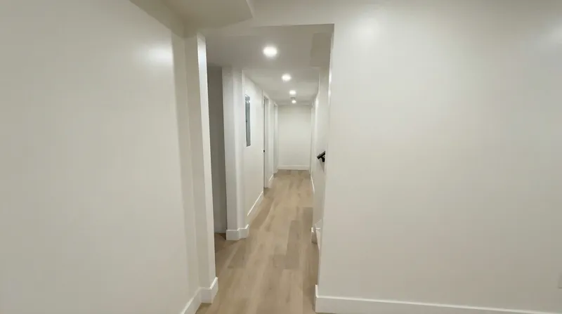 Finished basement hallway with recessed lighting