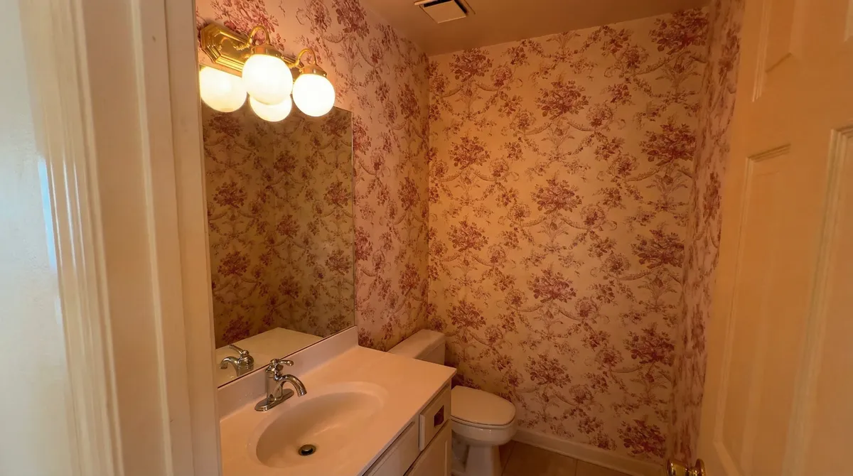 Bathroom with floral wallpaper before renovation
