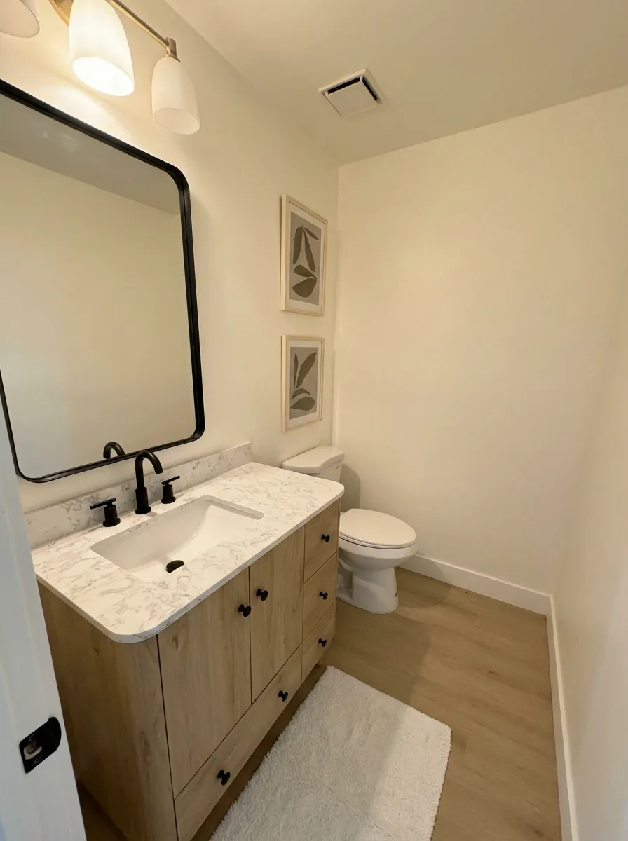 Modern bathroom with light wood vanity and marble counter