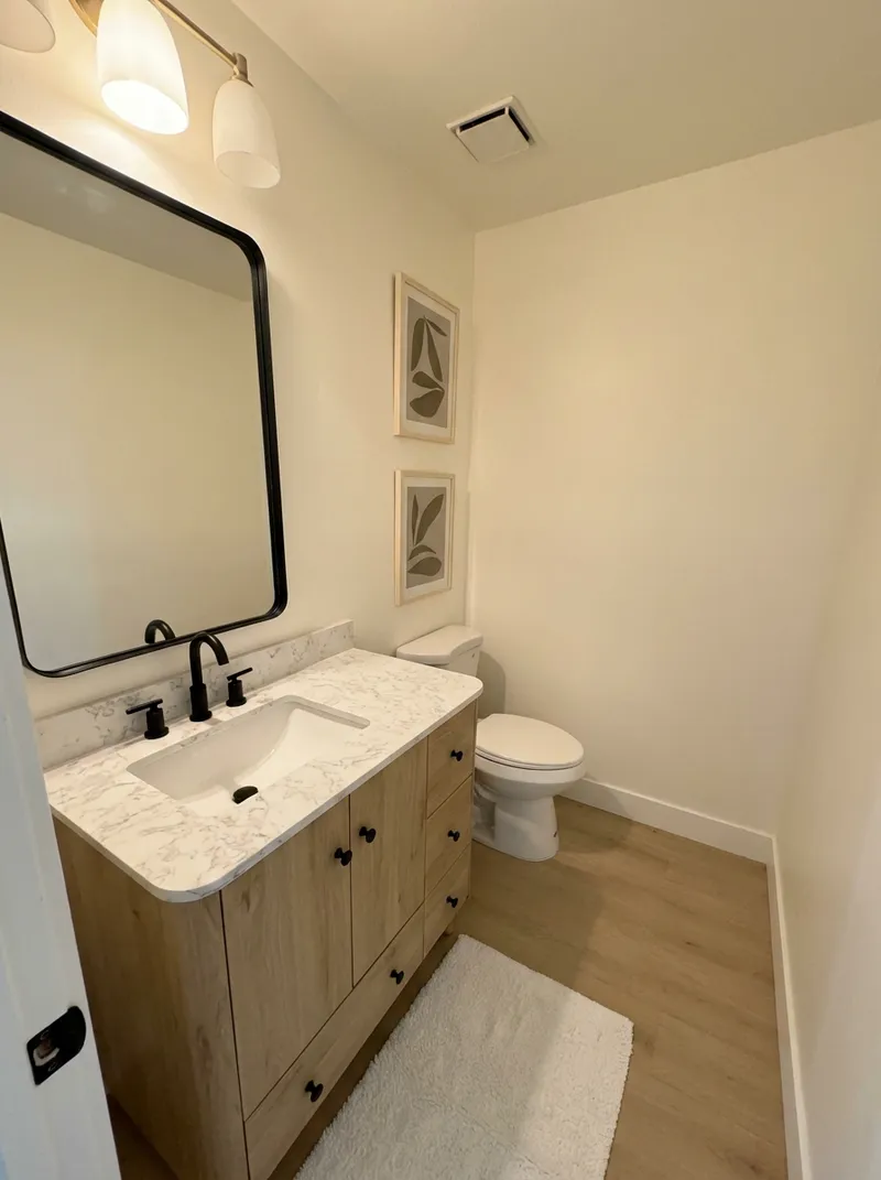 Modern bathroom with light wood vanity and marble counter