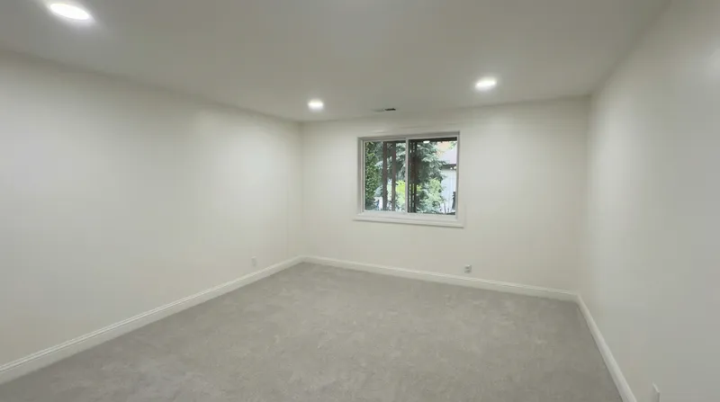 Finished bedroom with new carpet and recessed lighting