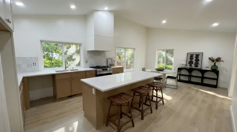 Kitchen island with bar stools and vaulted ceiling